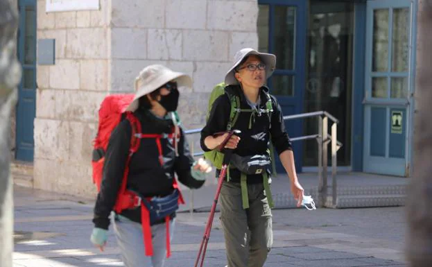 Dos peregrinos coreanos caminan por el Paseo del Espolón de la capital burgalesa